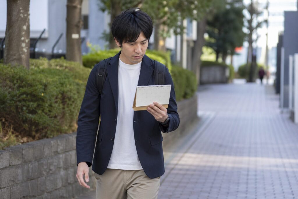 カレンダーを見ながら歩く人